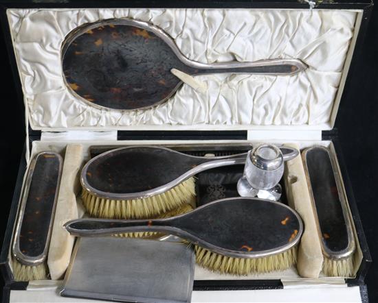 A 1920s cased silver and tortoiseshell six piece brush and mirror set, an aide memoire, a silver cigarette case and a match tidy.